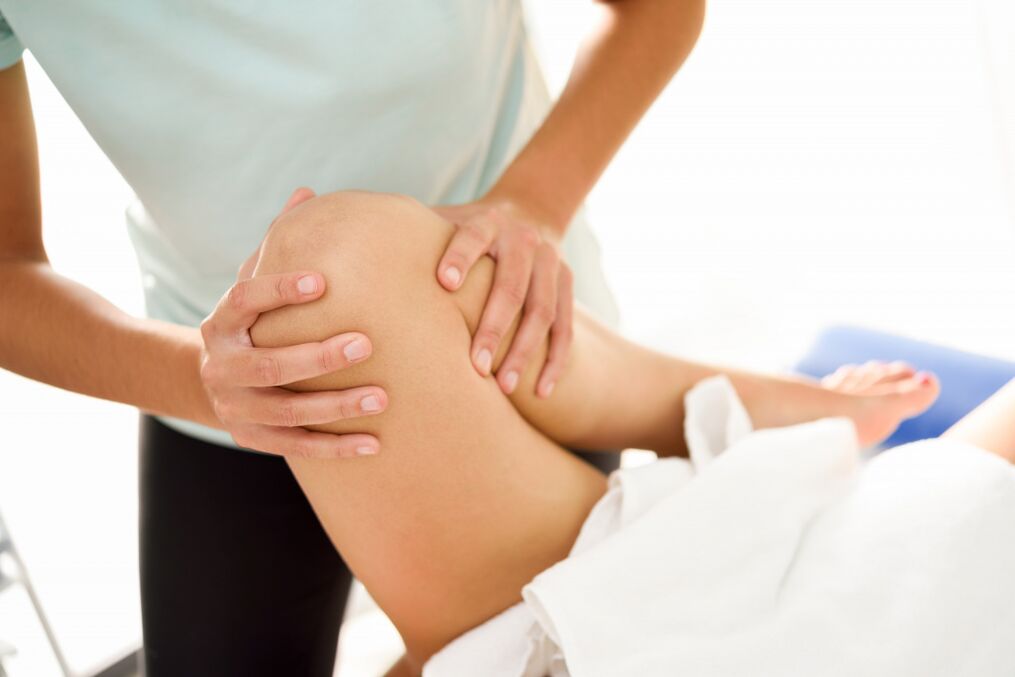 The expert does the therapeutic massage with knee arthrosis